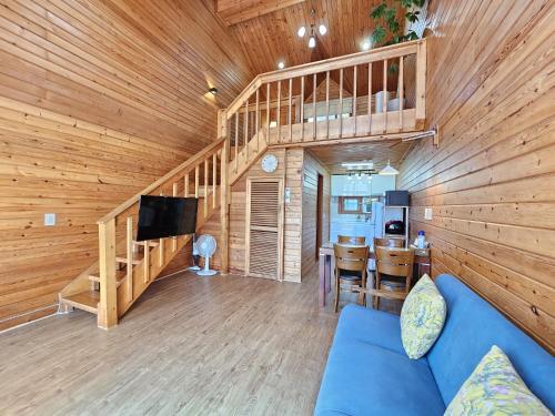 a living room with a blue couch in a cabin at Old Man And Sea in Seogwipo