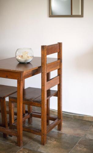 a wooden table with a chair and a bowl on it at hotel stella maris tulum in Tulum