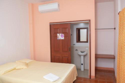 Pokój z łóżkiem i łazienką z umywalką w obiekcie Hotel Hellenika w mieście León