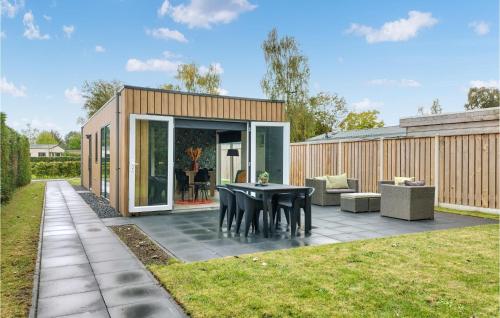 a small backyard with a black table and chairs at 2 Bedroom Awesome Home In Heinkenszand in Heinkensand