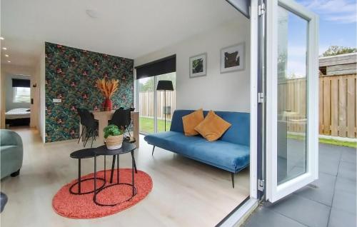 a living room with a blue couch and a table at 2 Bedroom Awesome Home In Heinkenszand in Heinkensand