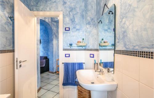 een blauwe en witte badkamer met een wastafel en een spiegel bij 2 Bedroom Amazing Apartment In Giardini Naxos in Giardini Naxos