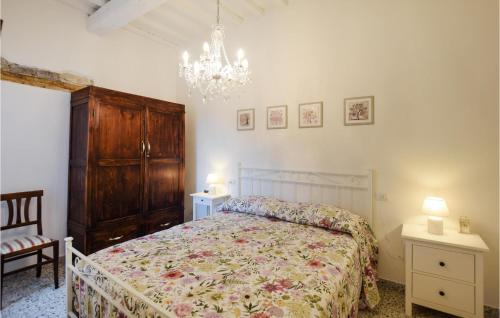 1 dormitorio con cama y lámpara de araña en 3 Bedroom Gorgeous Home In Palazzetto Nese, en Vicolo Rancolfo