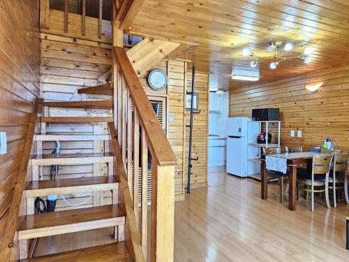 a kitchen and dining room with a staircase in a cabin at Old Man And Sea in Seogwipo