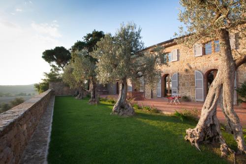 a large stone building with a tree in front of it at Borgo Sant'Ambrogio - Resort in Pienza