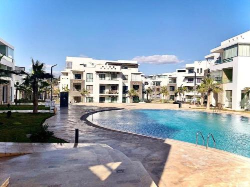 una gran piscina frente a algunos edificios en Appartement de luxe ,piscine,parking,Terrasse, en Agadir