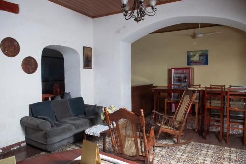 een woonkamer met een bank, stoelen en een tafel bij Hotel Hellenika in León