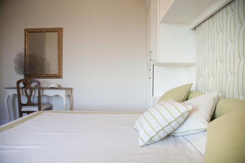 a bedroom with a bed with white sheets and pillows at Hotel Villa Maremonti in Marina di Massa