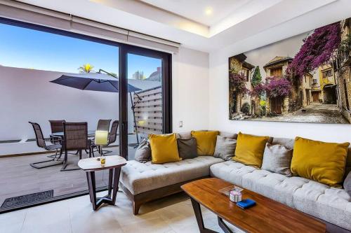 a living room with a couch and a table at A FEW BREEZY STEPS TO THE BEACH ~LUXURIOUS STAY~ in Puerto Vallarta