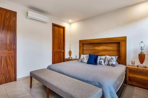 a bedroom with a large bed with a wooden headboard at A FEW BREEZY STEPS TO THE BEACH ~LUXURIOUS STAY~ in Puerto Vallarta