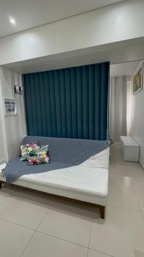 ein Schlafzimmer mit einem großen Bett mit einem blauen Vorhang in der Unterkunft Biquinha - Praça 22 de Janeiro in São Vicente