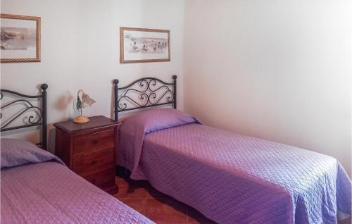 Nice Home In Limano With House A Mountain View في Cocciglia: غرفة نوم مع سريرين مع ملاءات أرجوانية وخزانة