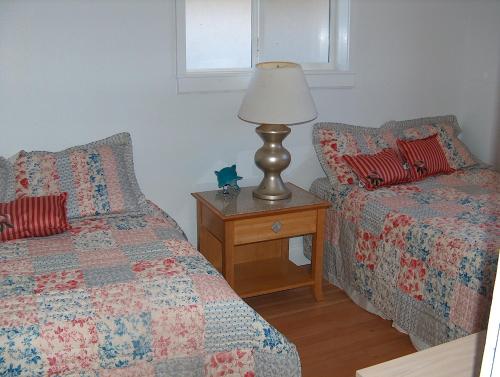 a bedroom with two beds and a lamp on a table at Moana Hale Nui in Hauula