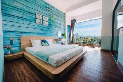 a bedroom with a blue accent wall and a bed at Blossom Sea Homestay Quy Nhơn in Quy Nhon