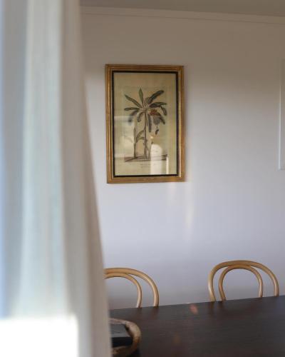 a dining room table with a picture of a palm tree at Bowentown Beach Holiday Park in Waihi Beach