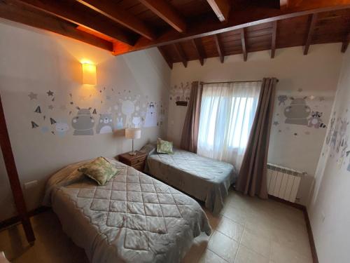 een slaapkamer met 2 bedden en een raam bij Lirios del Campo - Chumamaya Merlo SL in Merlo