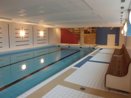 una gran piscina con 2 bancos en un edificio en Apartment im Haus Hanseatic mit Meerblick am Duhner Sandstrand, en Cuxhaven