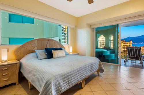a bedroom with a bed and a large window at Beach Front-Ocean Views-Marina Luxury Condo-BVG in Puerto Vallarta