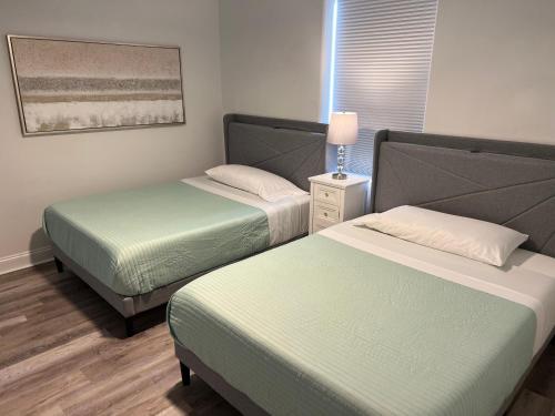 Habitación con 2 camas y lámpara. en Big Pool, stunning Lakeview, Sunrise, Disney # 710, en Orlando
