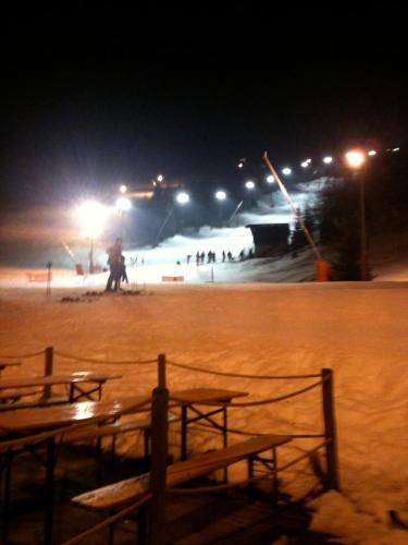 a snow covered ski slope at night with people at Hôtel Restaurant Wolf in Markstein 
