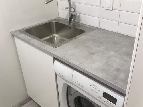 a kitchen with a sink and a washing machine at Holiday home LIMA II in Lima