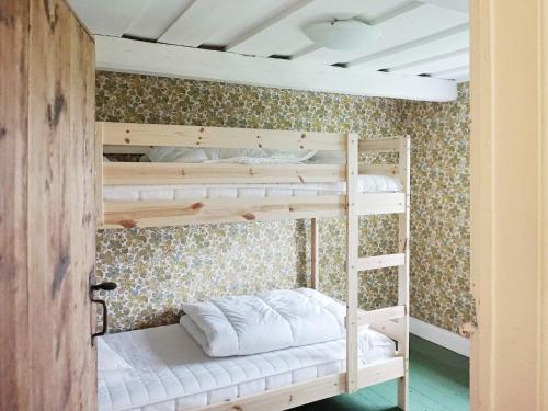 BjörklingeにあるHoliday home Björklingeの白いベッドが備わる小さな部屋の二段ベッド1台分です。