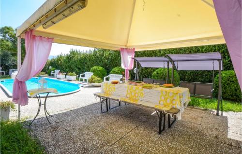 a yellow umbrella with a table in front of a pool at 4 Bedroom Lovely Home In Santa Luce in Santa Luce