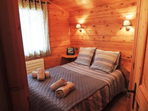 ein Schlafzimmer mit einem Bett in einer Blockhütte in der Unterkunft Chalet au calme avec sauna, proche des pistes, parking - FR-1-598-123 in Les Gets