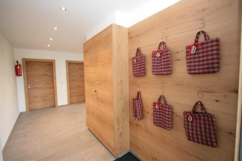 a wall with four red and white bags on it at Aktiv & Sport Apartments Oberjörg in Rattendorf