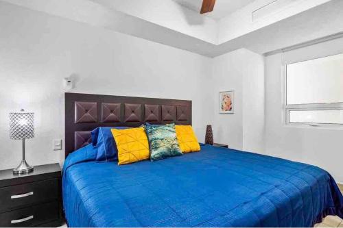 a bedroom with a large blue bed with yellow pillows at BEACH FRONT~ JACUZZI ~ SPECTACULAR OCEAN VIEWS in Puerto Vallarta