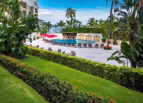 a resort with a swimming pool and a garden at BEACH FRONT~ JACUZZI ~ SPECTACULAR OCEAN VIEWS in Puerto Vallarta