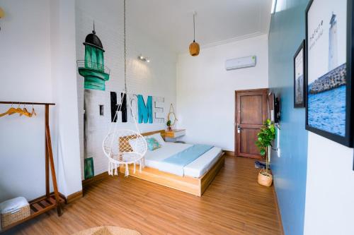 a bedroom with a bed and a chair in a room at Blossom Sea Homestay Quy Nhơn in Quy Nhon