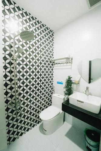 a bathroom with a white toilet and a sink at Blossom Sea Homestay Quy Nhơn in Quy Nhon