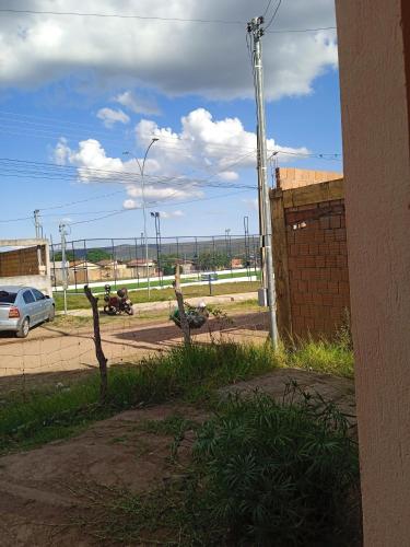 a view of a street with a car and a fence at Conforto in Alto Paraíso de Goiás
