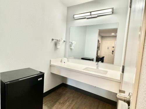 a bathroom with a sink and a large mirror at Motel 6-Bellflower, CA - Los Angeles in Bellflower