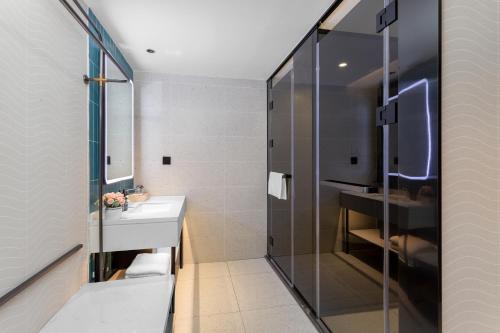 a bathroom with a sink and a glass shower at Guangzhou Yilin Hotel in Guangzhou