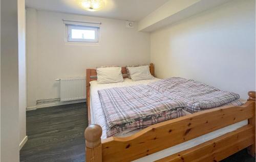1 dormitorio con cama de madera y ventana en Pet Friendly Apartment In Myggens With Kitchen en Myggenäs