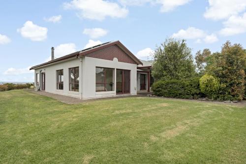 a house with a large lawn in front of it at Sea Breeze - Spacious home with lovely ocean views in Port Elliot