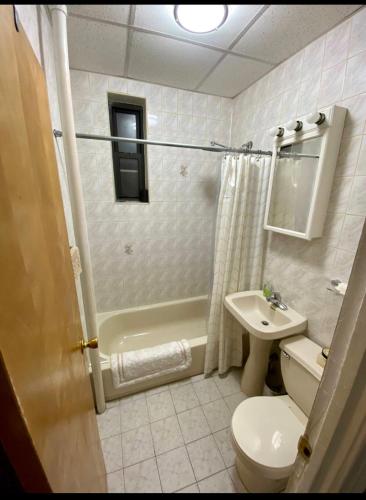 La salle de bains est pourvue de toilettes, d'une baignoire et d'un lavabo. dans l'établissement Woodside, queens, à Woodside