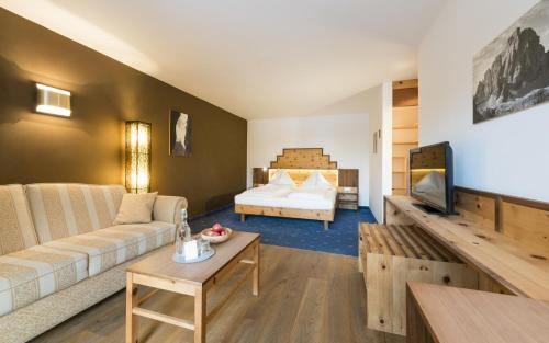 - un salon avec un canapé et un lit dans l'établissement Hotel Kreuzberg Monte Croce, à Sesto