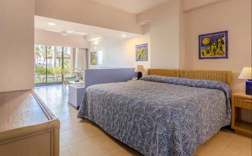 a bedroom with a bed with a blue and white bedspread at socio zuana beach resort in Santa Marta