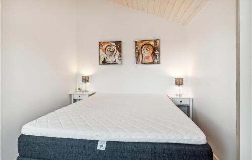 a bed in a room with three pictures on the wall at 2 Bedroom Amazing Apartment In Slagelse in Slagelse