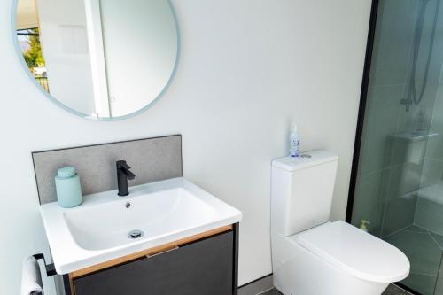 uma casa de banho com um lavatório, um espelho e um WC. em Ben Ohau Views The Studio em Twizel