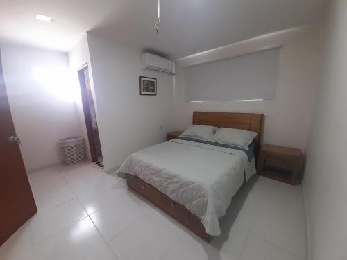 um quarto com uma cama num quarto branco em MALALA3 depa amoblado em Sincelejo