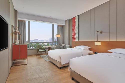 FuzhouにあるDoubleTree by Hilton Jiangxi Fuzhouのベッド2台とデスクが備わるホテルルームです。