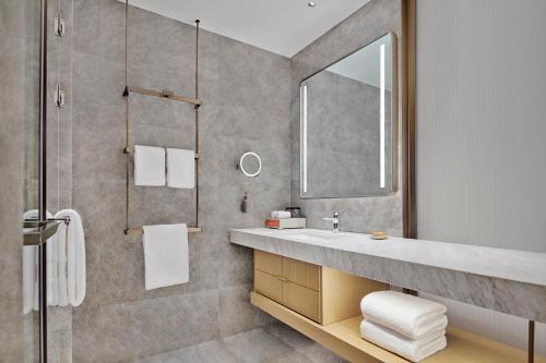 a bathroom with a sink and a mirror at DoubleTree by Hilton Jiangxi Fuzhou in Fuzhou