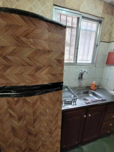 a kitchen with a sink and a wooden wall at Temporada em praia grande in Praia Grande