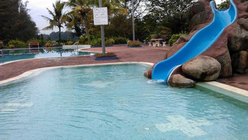 a blue water slide in a swimming pool at Nestle Homestay@Batu Pahat in Batu Pahat