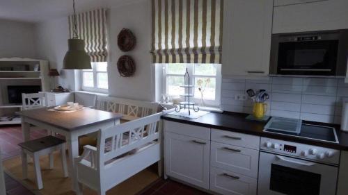 a kitchen with a table and a stove top oven at Reetdachhaushaelfte-1 in Sankt Peter-Ording