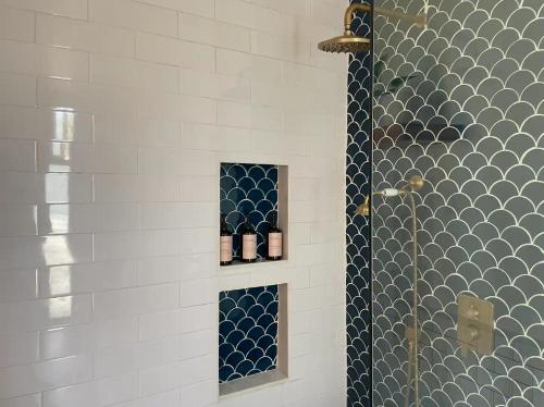 a bathroom with a shower with blue and white tiles at Villa Markisa - luxury private pool villa Gili Air in Gili Air